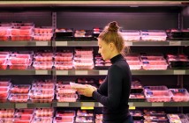 Woman purchasing a packet of meat at the supermarket