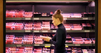 Woman purchasing a packet of meat at the supermarket